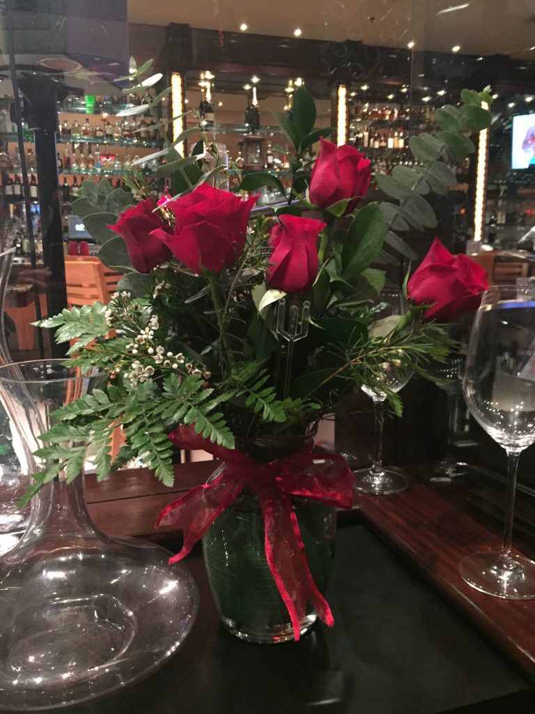 Bouquet of roses on a table with empty wine glasses at Kirby's Steakhouse