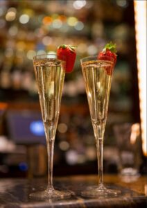 Two glasses of champagne with strawberry garnishes at Kirby's Steakhouse