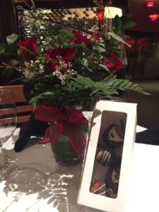 A bouquet of roses and a box of chocolate-covered strawberries are on the table at Kirby's Steakhouse